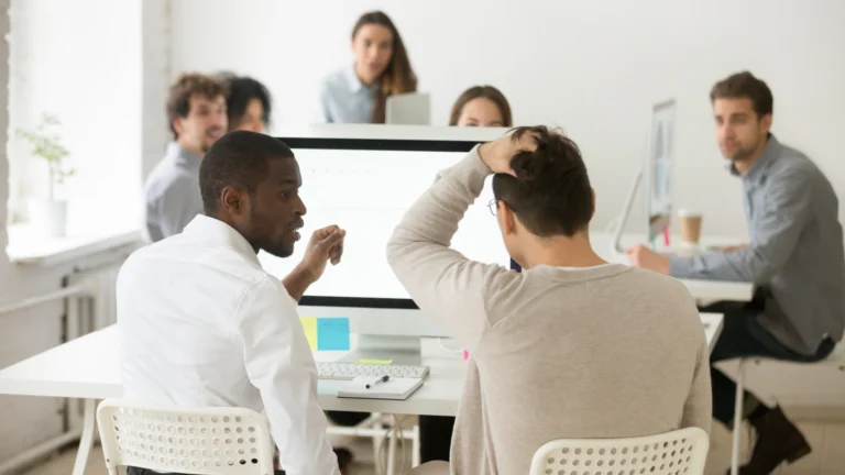 equipe sentada ao redor de uma mesa discute decisões a tomar com a liderança em tempos de crise