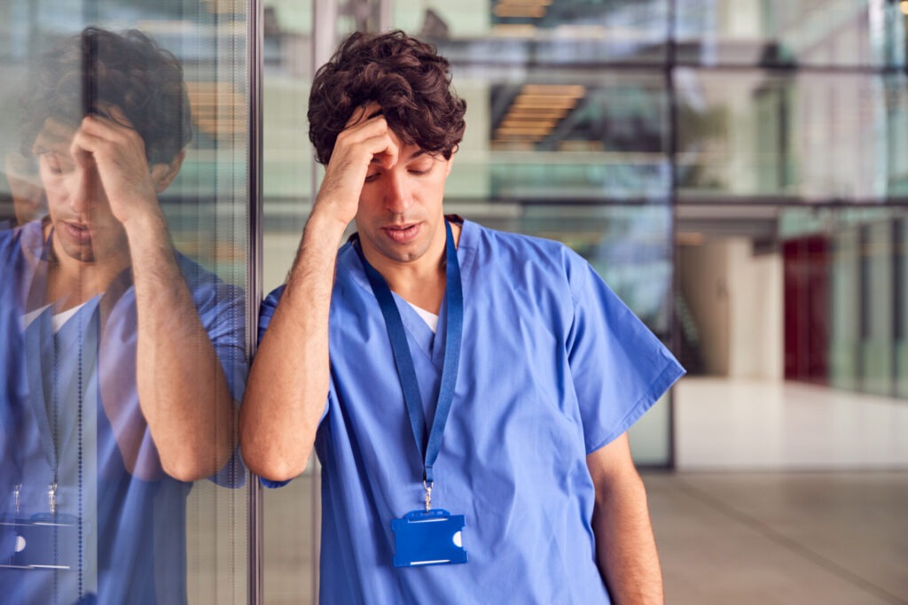 NR-33 e NR-17: quais os riscos ocultos no trabalho que sua empresa pode estar ignorando? 2 tired young male doctor wearing scrubs leaning aga 2024 10 22 04 55 53 utc
